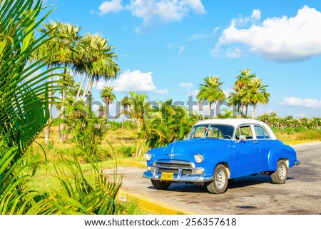 HAVANA, CUBA - DECEMBER 2, 2013: Blue classic American car on one of the streets of Havana, where old cars are relic of Cuban revolution and still attracts many tourists.