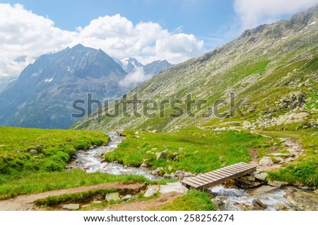 Beautiful alpine landscape with a mountain brook on the background of the high peaks of the mountains, the Alps, Austria