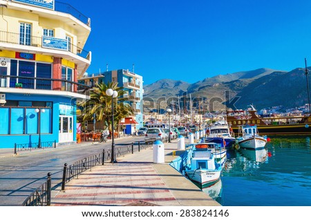 KALYMNOS, GREECE - MAY 01, 2015: Yachts moored in small port with colorful buildings on Kalymnos, Greece