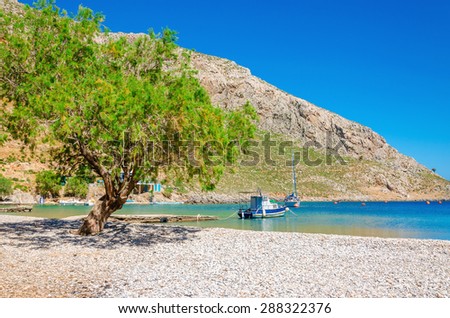 Greek pebble beach in a beautiful quiet bay, Greek Islands, Aegean Sea