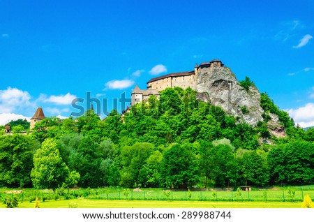 Orava Castle on a background of green trees and blue sky, one of the most beautiful Slovak castles, Orava Podzamcze, Slovakia