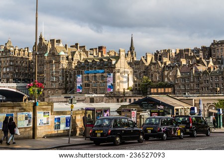 Edinburgh, Scotland - September 14, 2014: trio of black cab taxis waiting for pick up on Waverley Bridge on a sunny late summer afternoon.
