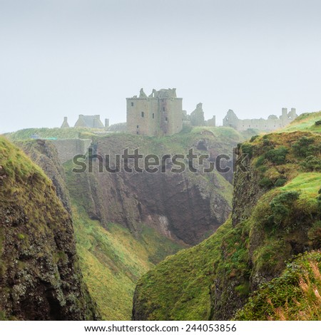Dunnottar castle, Stonehaven, Aberdeen, Scotland. Evocative fortress ruins shrouded in mist and flanked by scarped rocky formations. This landmark\'s history spans since the Picts until today