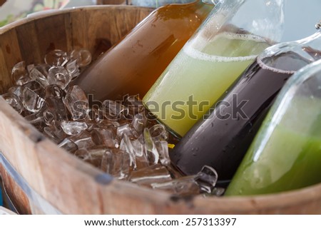 Mix cold juice bottle in wooden ice bucket