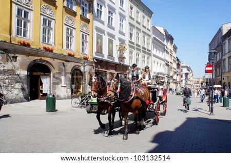 KRAKOW, POLAND - MAY 20: Horse-drawn carriage at City Square on May 20, 2012 in Krakow, Poland. Horse-drawn carriage tour of Krakow is a great attraction for tourists from around the world.