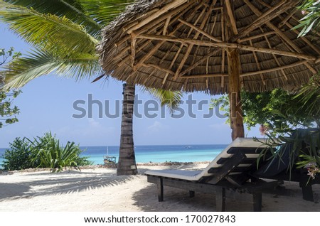 Lounges under umbrella at the shore of Indian ocean, Zanzibar, Tanzania
