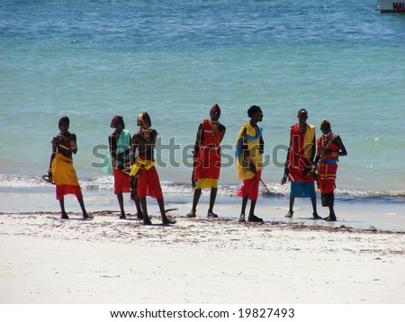 Diani Resort (30 km south of Mombasa), Kenya, Africa 02 May 2007 : Group of male Masai on a beautiful kenyan beach in traditional clothes. Amaizing colors - light sand blue sky and turquoise ocean.