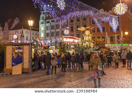 WROCLAW, POLAND - DECEMBER 21: Residents and tourists visit the Christmas market in the Old Market Square in front of City Hall on 21 December 2014 in Wroclaw, Poland.