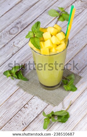 Fresh mango fruit juice in a glass and slices of mango.  Close-up. Studio photography.