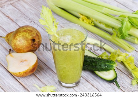 Fresh cucumber, pear and celery juice. Slices of fruits and vegetables on wooden background
