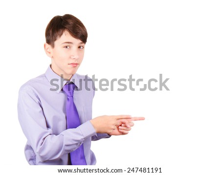 Pointing your product. Portrait of handsome teen boy in shirt and tie pointing copy space and smiling isolated on white background
