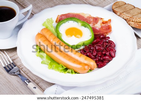 Egg fried in a green pepper, sausages, bacon and red beans