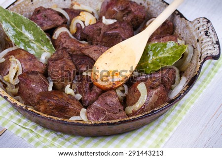 Sauteed liver with onions in pan