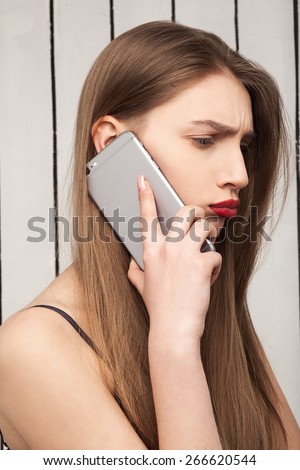 beautiful, sad, upset girl talking on the phone model, red lips, professional makeup, hairstyle