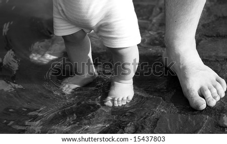 Father son legs in water black white