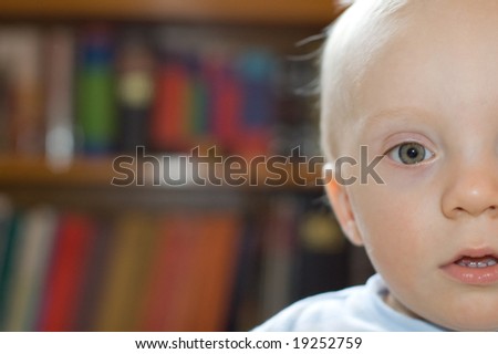 Surprised boy indoor bookshelf