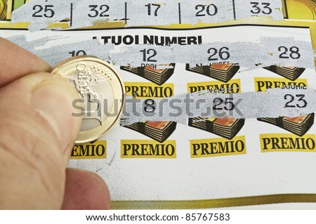 a  human hand is scratching a lottery ticket
