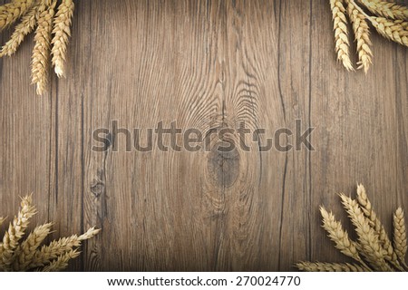 Wheat spikes on the dark wooden board