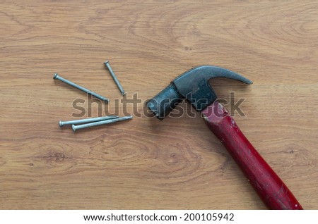 Old hammer and nails on wood table