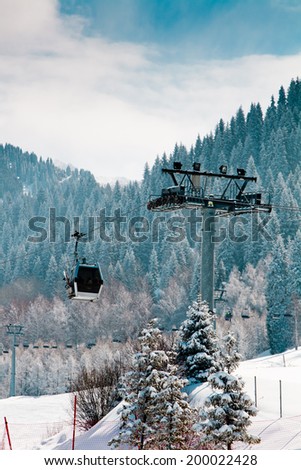 Ski lift at the snow covered mountains background