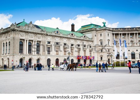 Vienna, Austria - April 3, 2015: Hofburg palace and square view, people walking and fiaker with white horses  in Vienna, Austria