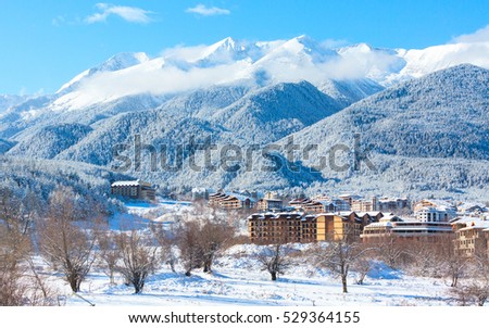 Wooden chalet, houses and snow mountains landscape panorama in bulgarian ski resort Bansko, Bulgaria
