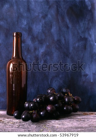 Wine bottle and grapes isolated on painted background