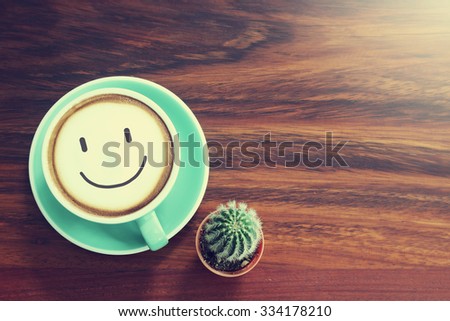 Coffee cup & Cactus on wooden background with vintage filter
