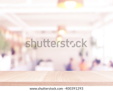 Wood table top and blurred restaurant interior background with vintage filter - can used for display or montage your products.
