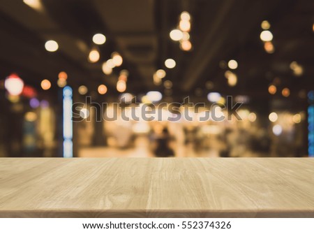 Wood table top and blurred bokeh cafe and restaurant background with vintage filter - can used for display or montage your products.
