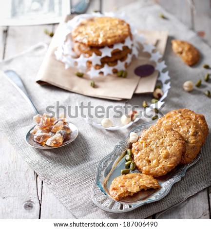 Caramel florentine cookies with cane sugar pieces on a textile and wooden background