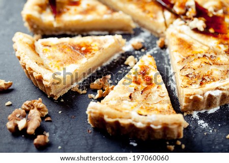 White chocolate, rum and caramel tart on a stone plate on a wooden background - stock photo