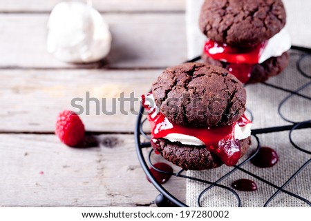 Chocolate cookie sandwich with a raspberry jam and meringue