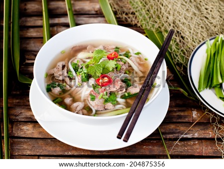 Traditional Vietnamese beef soup pho on a wooden background - stock photo