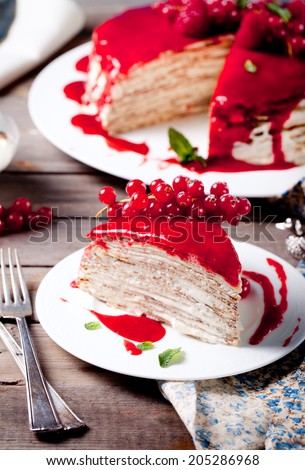 Traditional crepe cake with custard cream and fresh berry topping on a wooden background