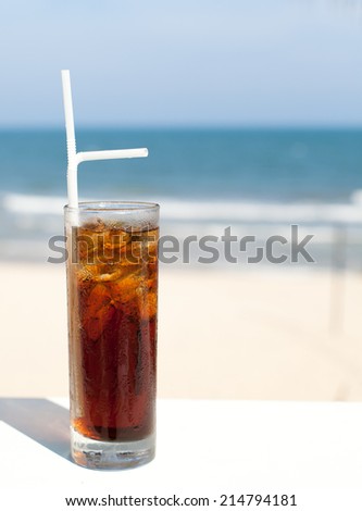 Iced soda drink in a glass on a sea, ocean, beach , summer background