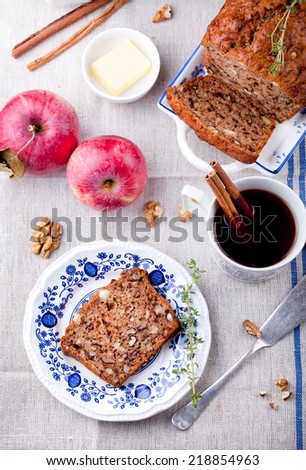 Apple, walnut cake, loaf, bread with fresh apples and cinnamon sticks on a textile blue and white background. Selective focus.