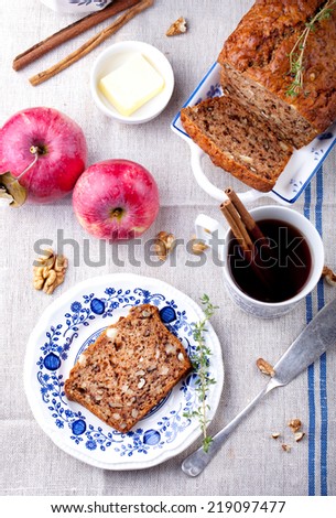 Apple, walnut cake, loaf, bread with fresh apples and cinnamon sticks on a textile blue and white background. Selective focus.