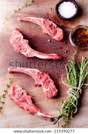 Raw meat, mutton, lamb rack with fresh herbs on a white paper background