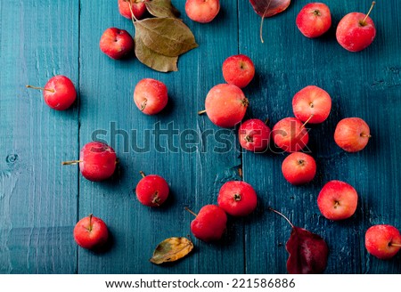 Red apples and leaves on a wooden  blue, turquoise background
