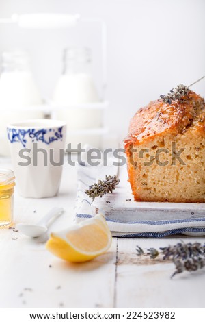 Lavender, lemon cake with fresh lemons and lavender flowers on a white wooden background.