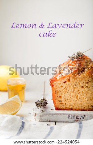 Lavender, lemon cake with fresh lemons and lavender flowers on a white wooden background.