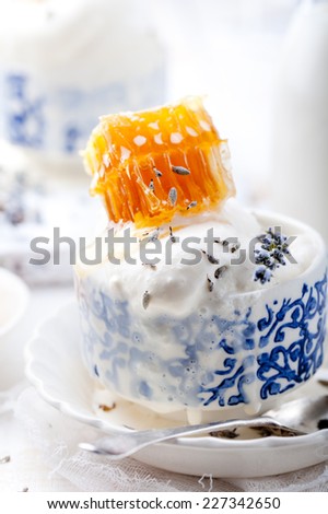 Lavender honey ice cream in a blue ceramic bowl on a white background