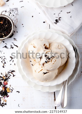 Ice cream with Earl grey tea flavor  in  white ceramic bowl on a white wooden background