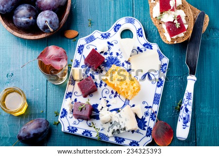 Crostini, bruschetta with plum, berry marmalade  and goat cheese on a blue turquoise blue background