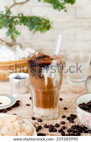 Ice coffee with condensed milk, traditional Vietnamese, Thai  coffee with coffee beans on a wooden background