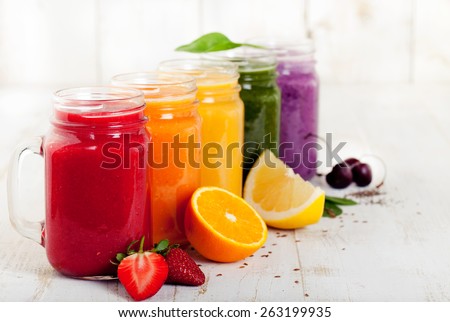 Smoothies, juices, beverages, drinks  variety with fresh fruits and berries on a white wooden background.