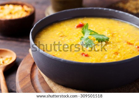 Red lentil Indian soup with flat bread on a wooden background. Masoor dal.