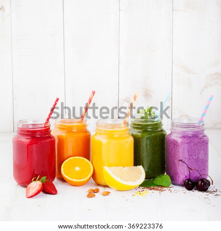 Smoothies, juices, beverages, drinks variety with fresh fruits and berries on a white wooden background Copy space