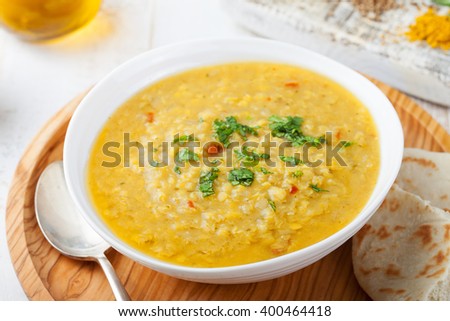 Lentil soup with pita bread in a ceramic white bowl on a wooden background